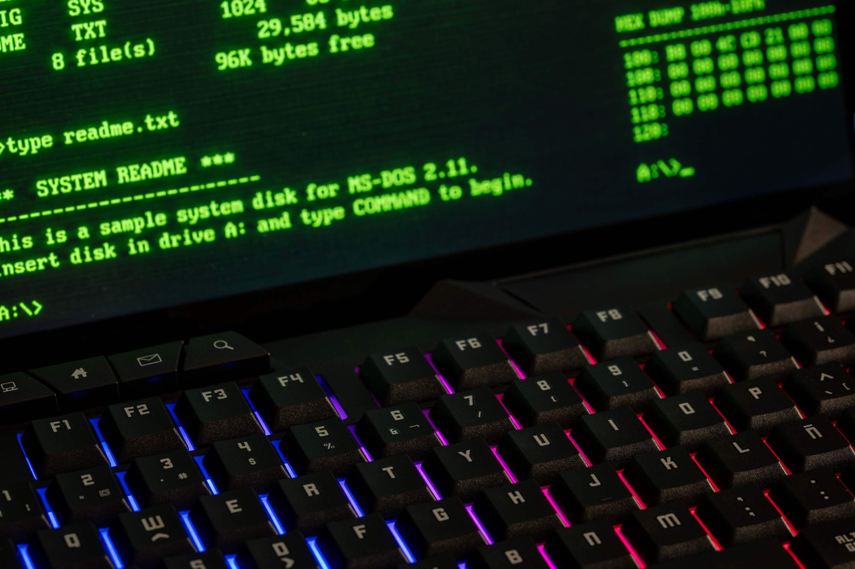 Hands on a keyboard beside a terminal session with MS-DOS commands